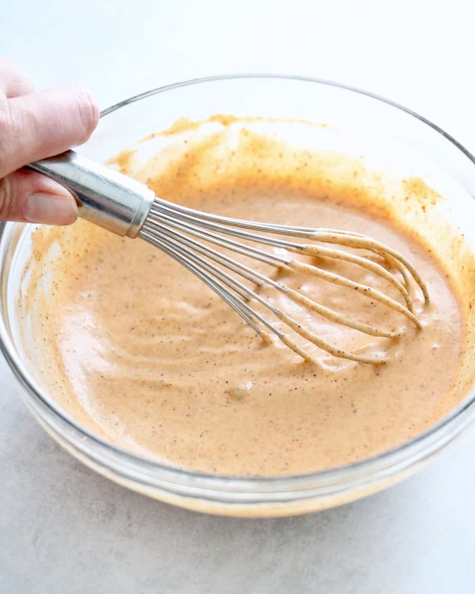 salad dressing being whisked in a bowl