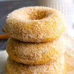 Close up of Stack of Healthy Baked Pumpkin Donuts with a cup of coffe next to it
