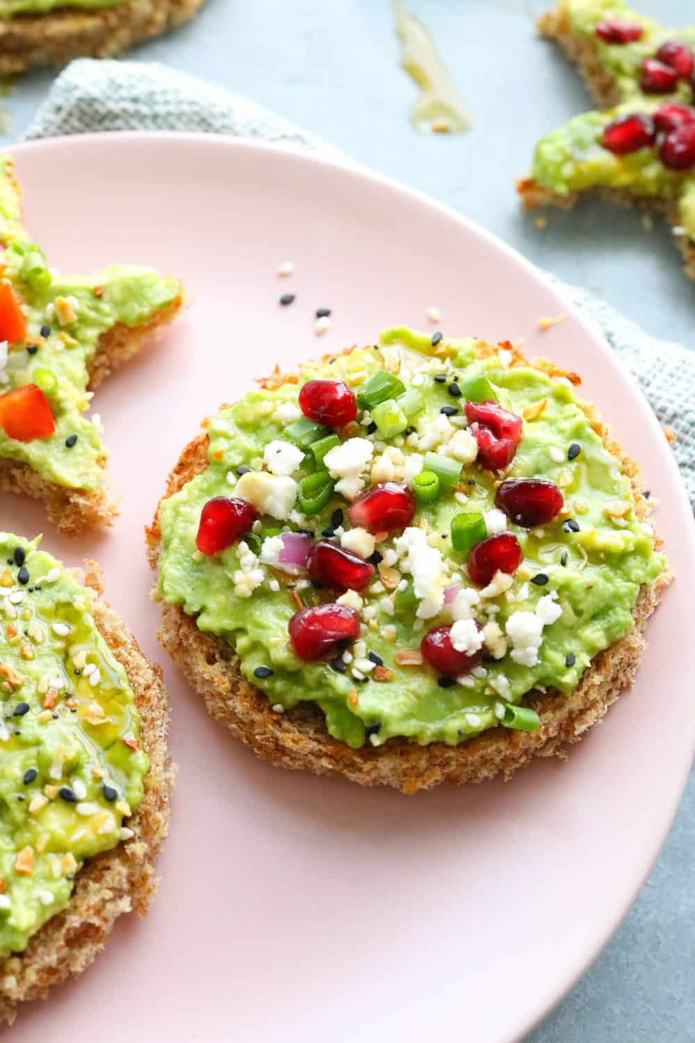 round avocado toast topped with pomegranate seeds and feta_