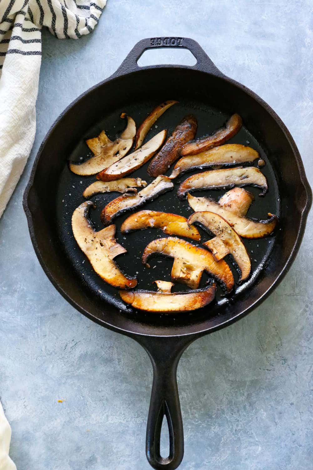 sliced portobello mushrooms in a cast iron pan