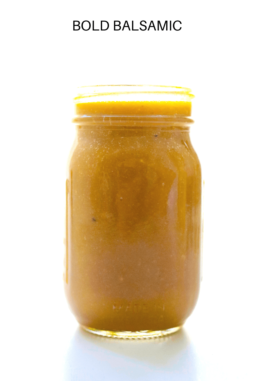 Balsamic dressing in a jar on a white surface