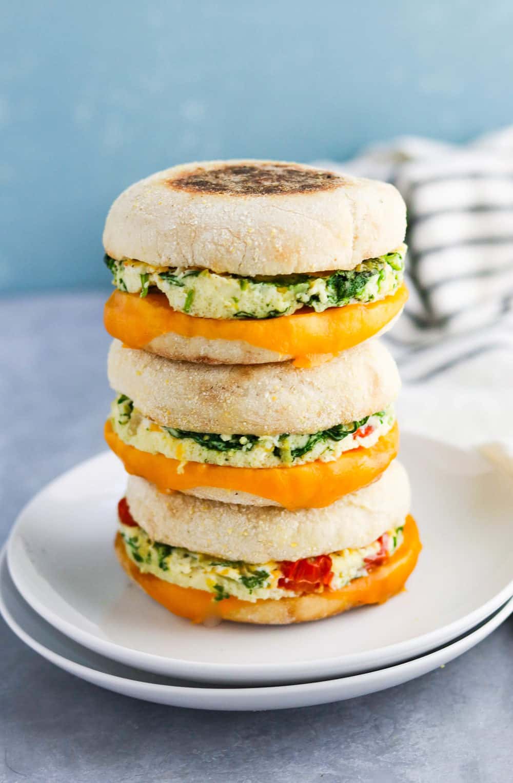 stack of 3 healthy breakfast egg sandwiches on top of a white plate