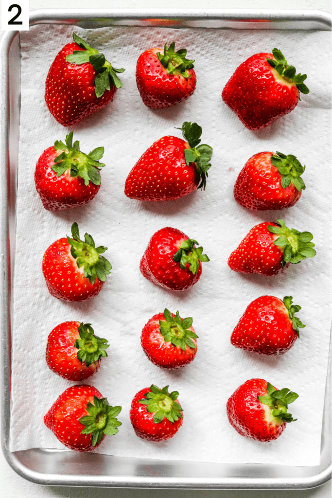 Fresh cleaned strawberries on tray on top of a clean paper towel. 