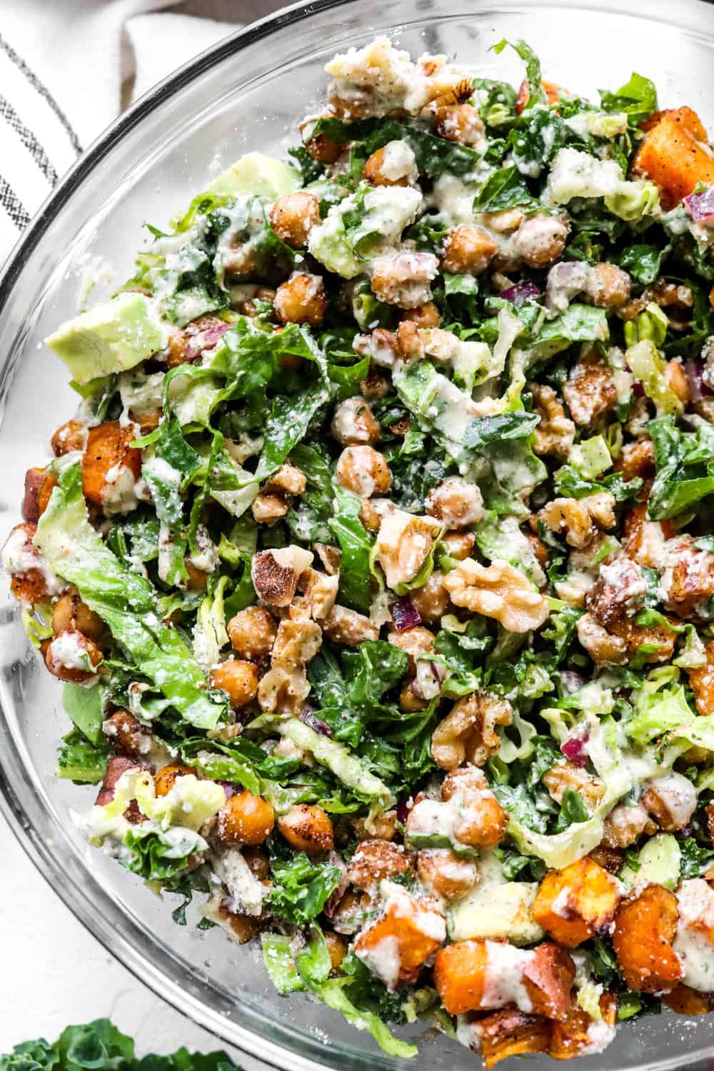 mixed up kale caesar salad with chickpeas in a round bowl