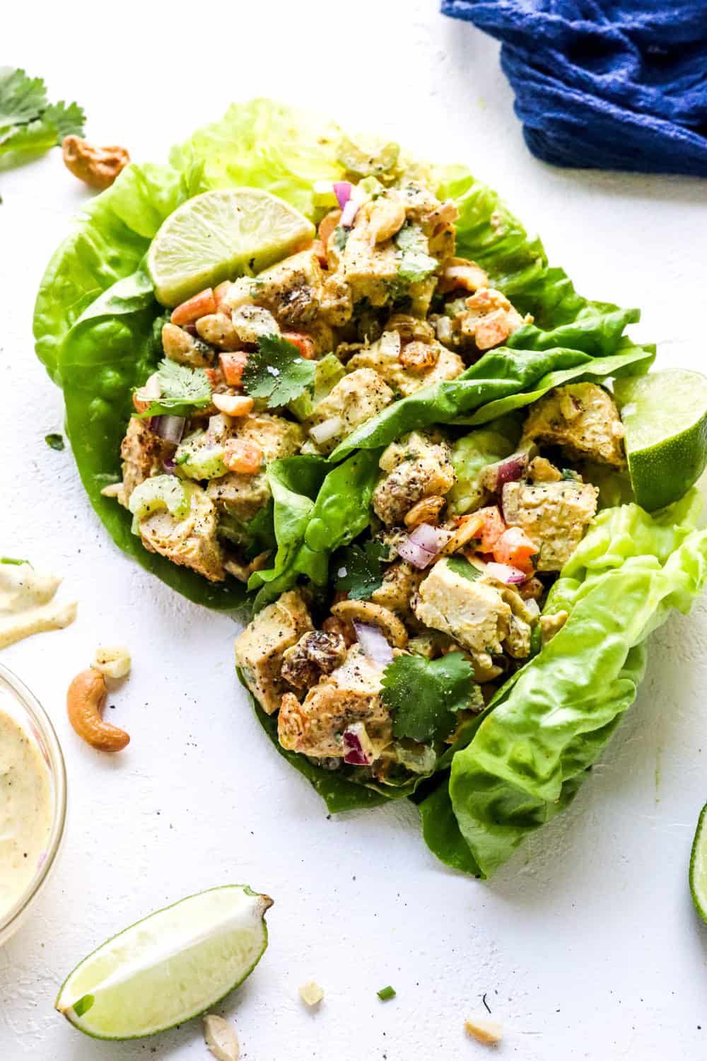 Lettuce cups filled with healthy creamy chicken salad on a white surface