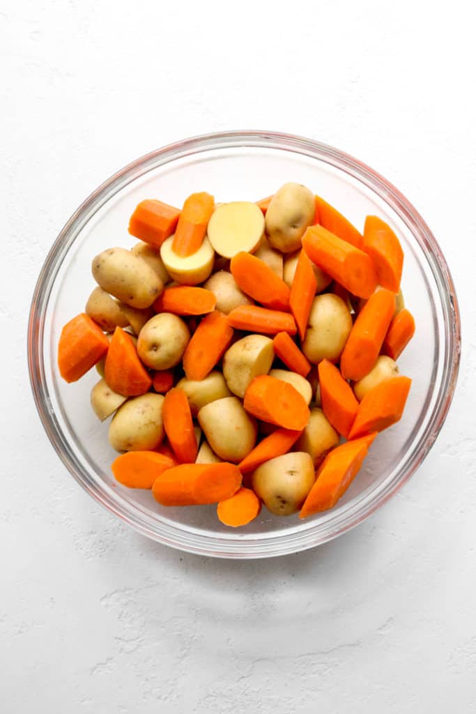 Diced potatoes and carrots in a round glass bowl 