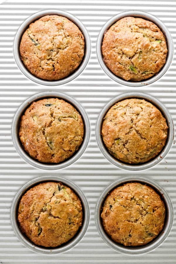 6 baked healthy zucchini muffins in a metal muffin pan