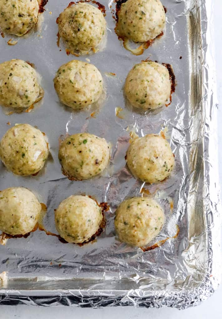Cooked turkey meatballs on a foil lined pan