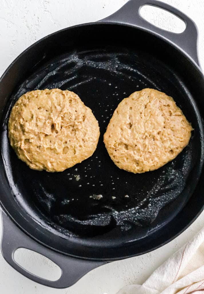 Cooking pancakes batter in a round black pan