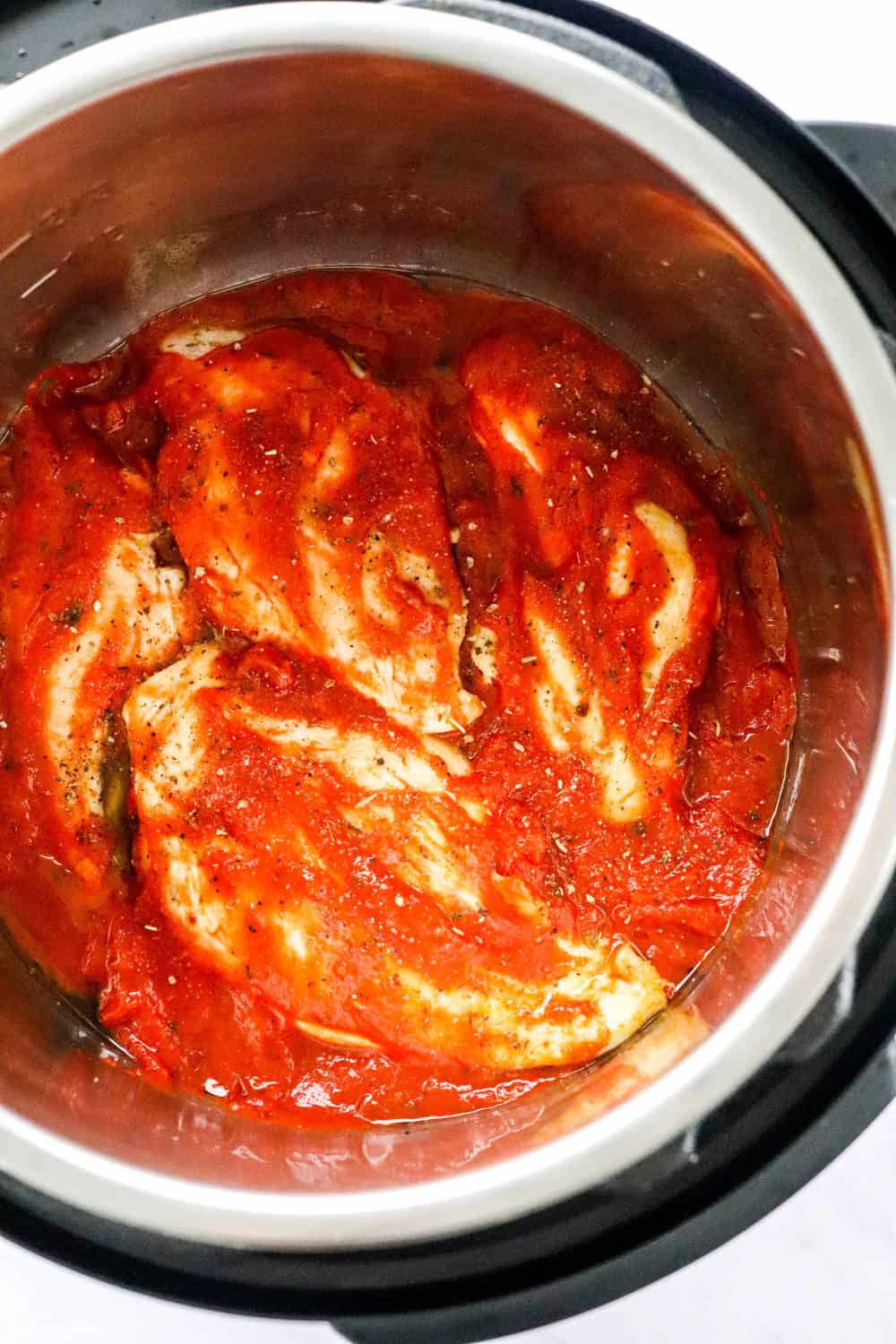 Cooked chicken over tomato sauce in an Instant Pot