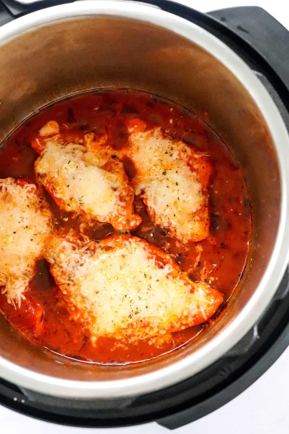 Cooked chicken parmesan in the Instant Pot topped with melty cheese