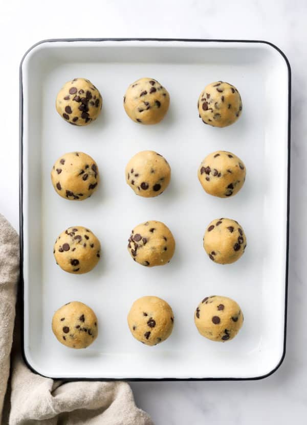 Cookie dough rolled into balls on a white platter.