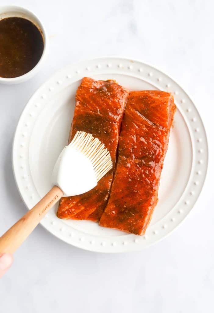 Brushing seasoning onto raw salmon