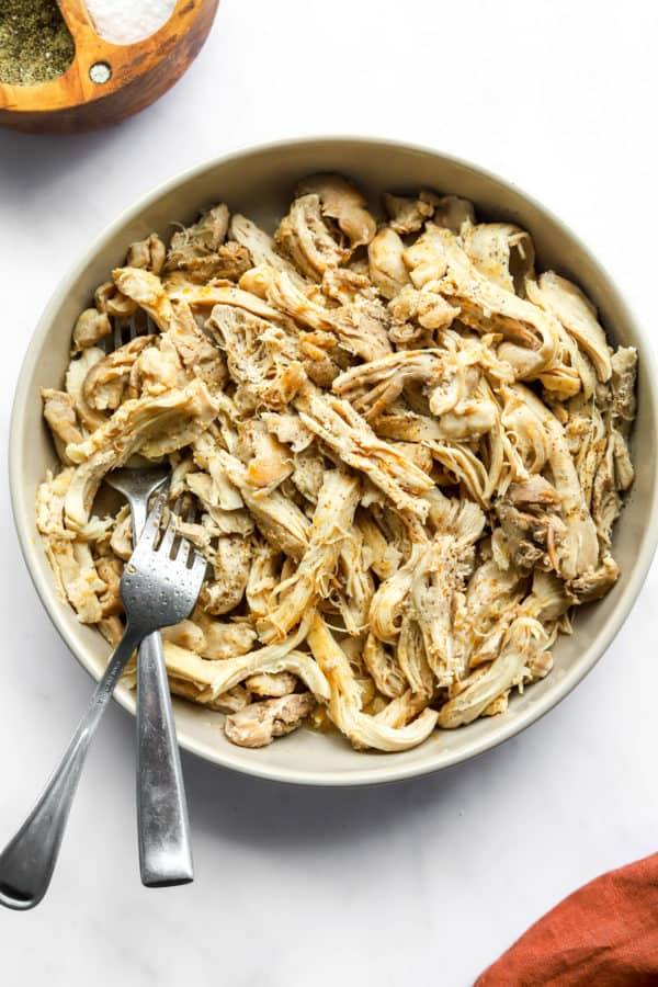 Shredded chicken in a dish with two forks in it.