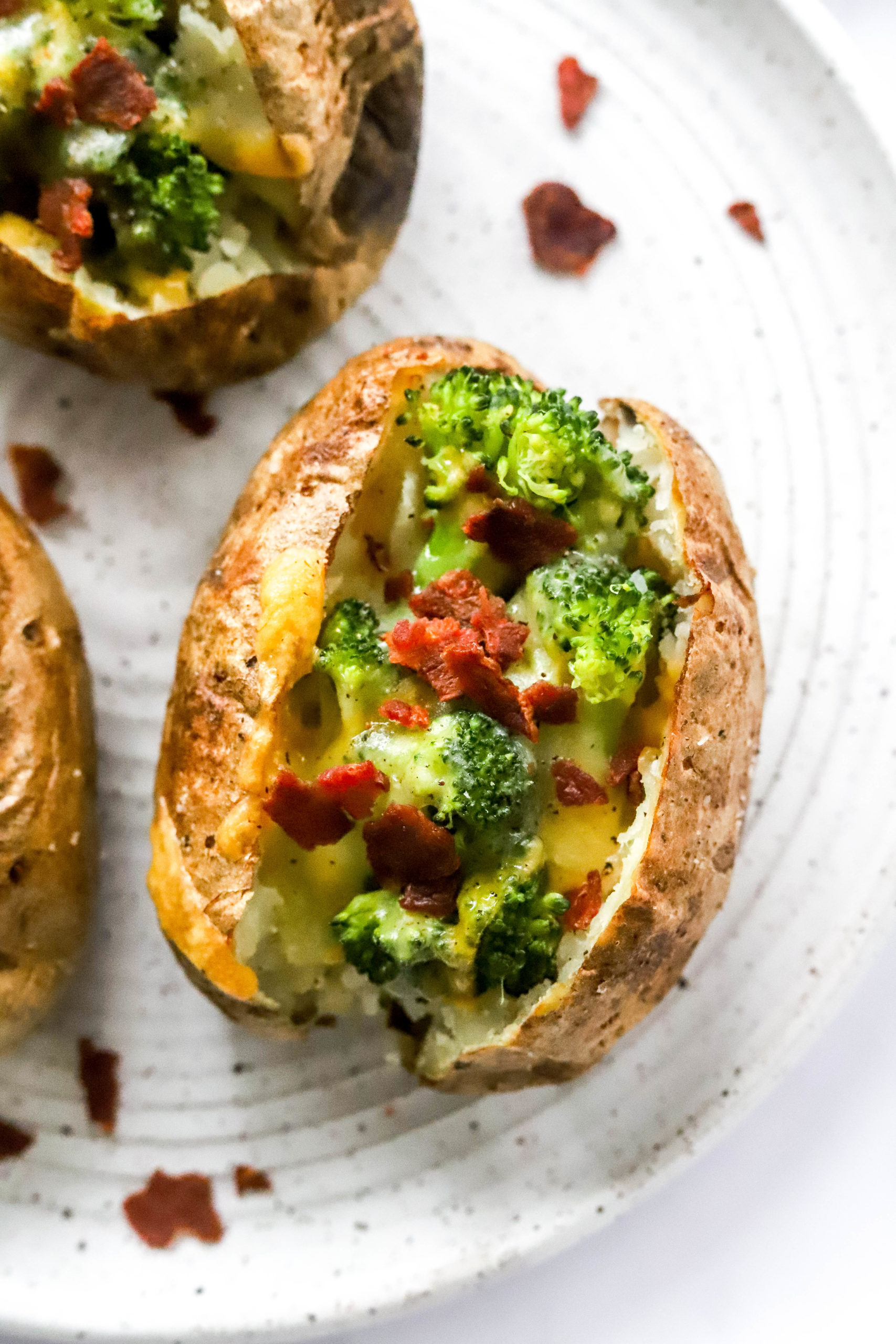 Air fryer baked potatoes filled with broccoli, melty cheese and bacon. 