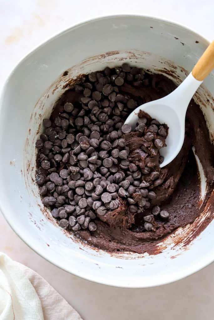 Cookie batter in a bowl with chocolate chips in it. 
