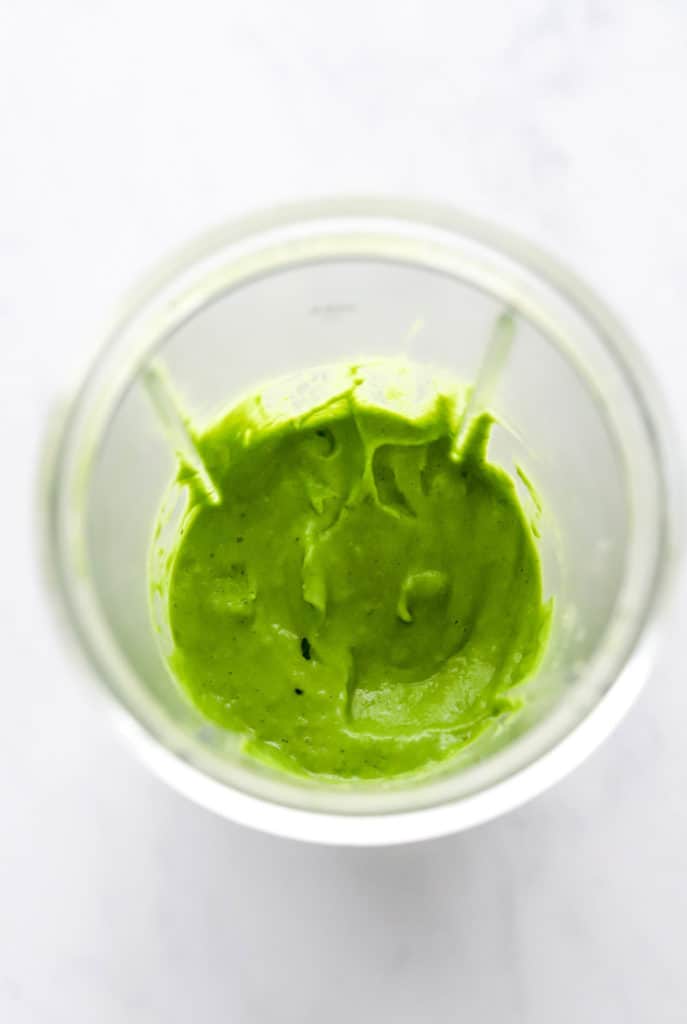 Blended green cilantro dressing in a blender pitcher. 