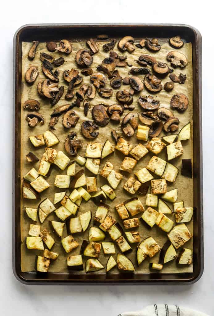 Roasted diced eggplant and mushrooms on a baking sheet. 