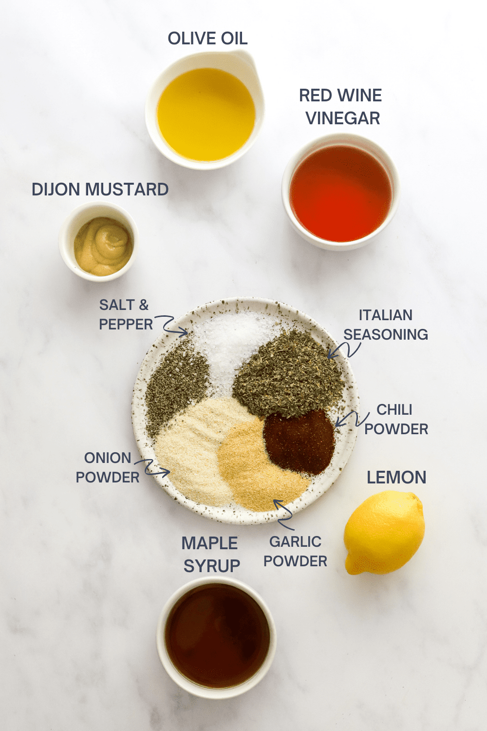 Italian dressing ingredients on a white surface with labels above the top of each ingredient. 