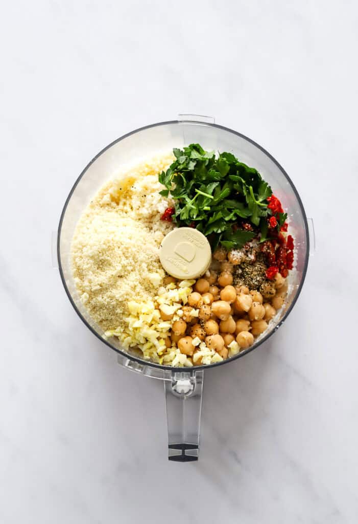 Cauliflower rice, chickpeas and herbs in a food processor before being blended. 