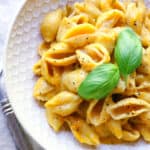 Instant Pot Butternut Squash Mac and Cheese in a bowl topped with basil leaves