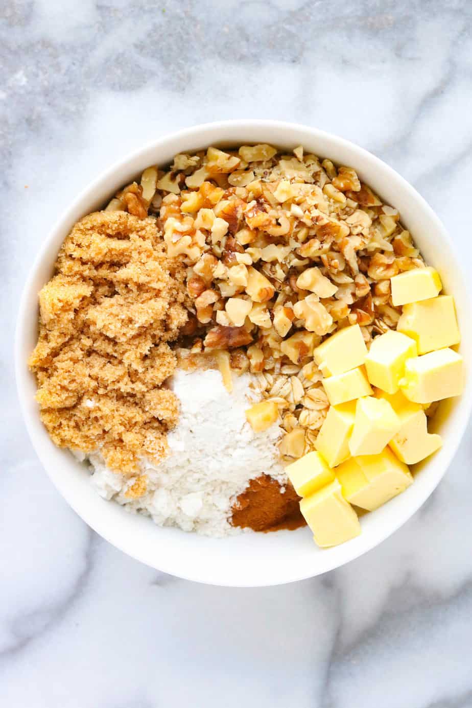 Nut and oat crumble topping ingredients in a white bowl