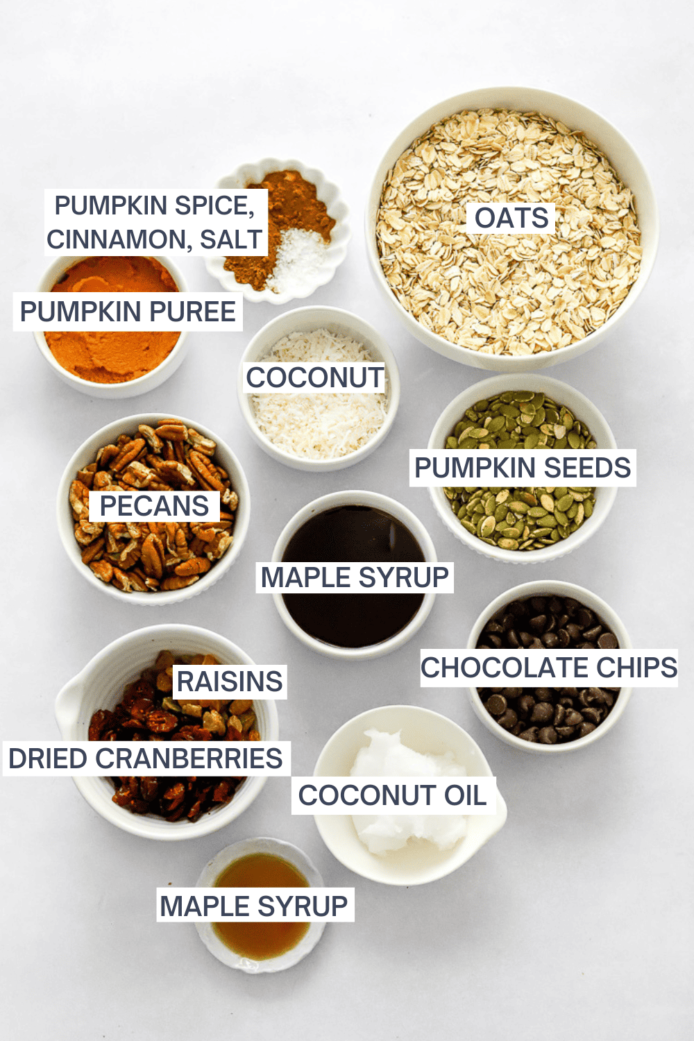 Ingredients for granola in bowls with labels over each ingredient. 