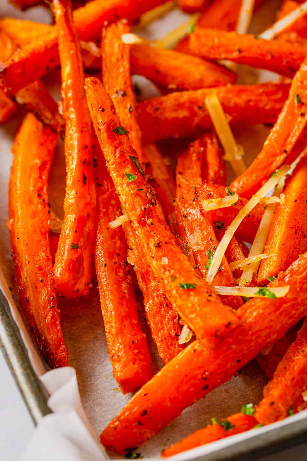 Crispy carrot fries on a lined pan.