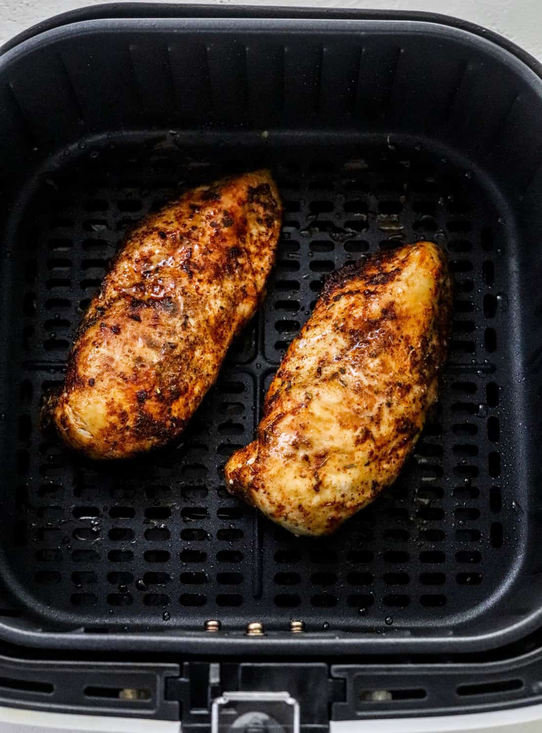 Cooked crispy boneless chicken breast in an air fryer basket