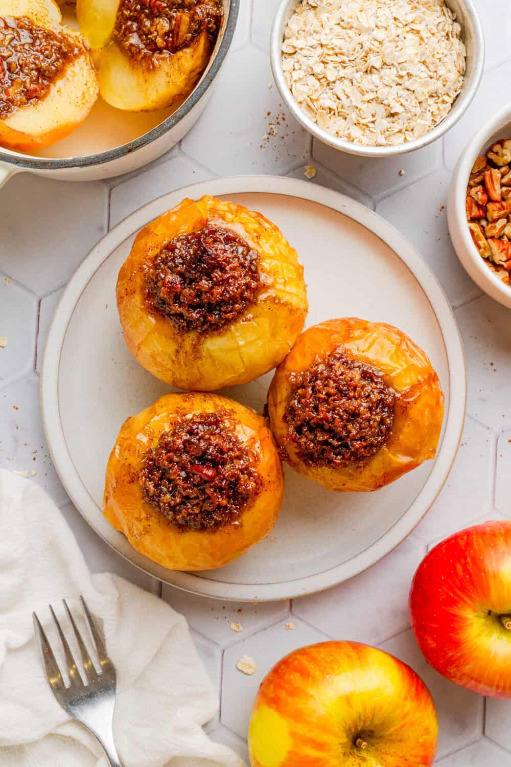 Plate of oat and pecan sweet filled air fried apples with more behind it.