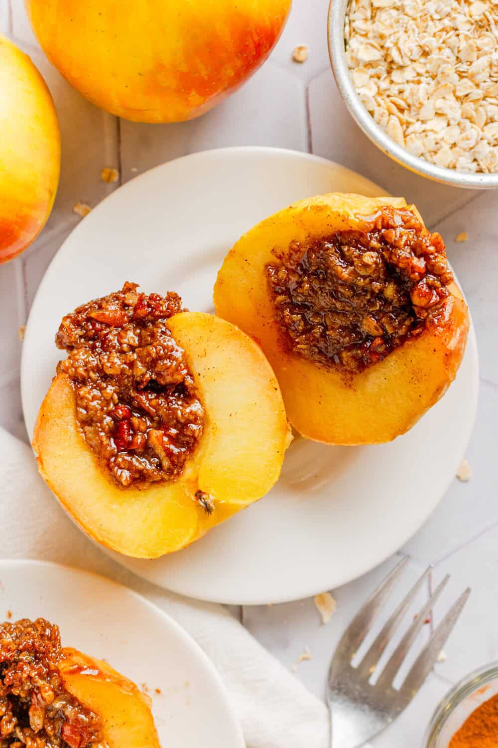 Sliced air fryer baked apples on a plate with more around it.
