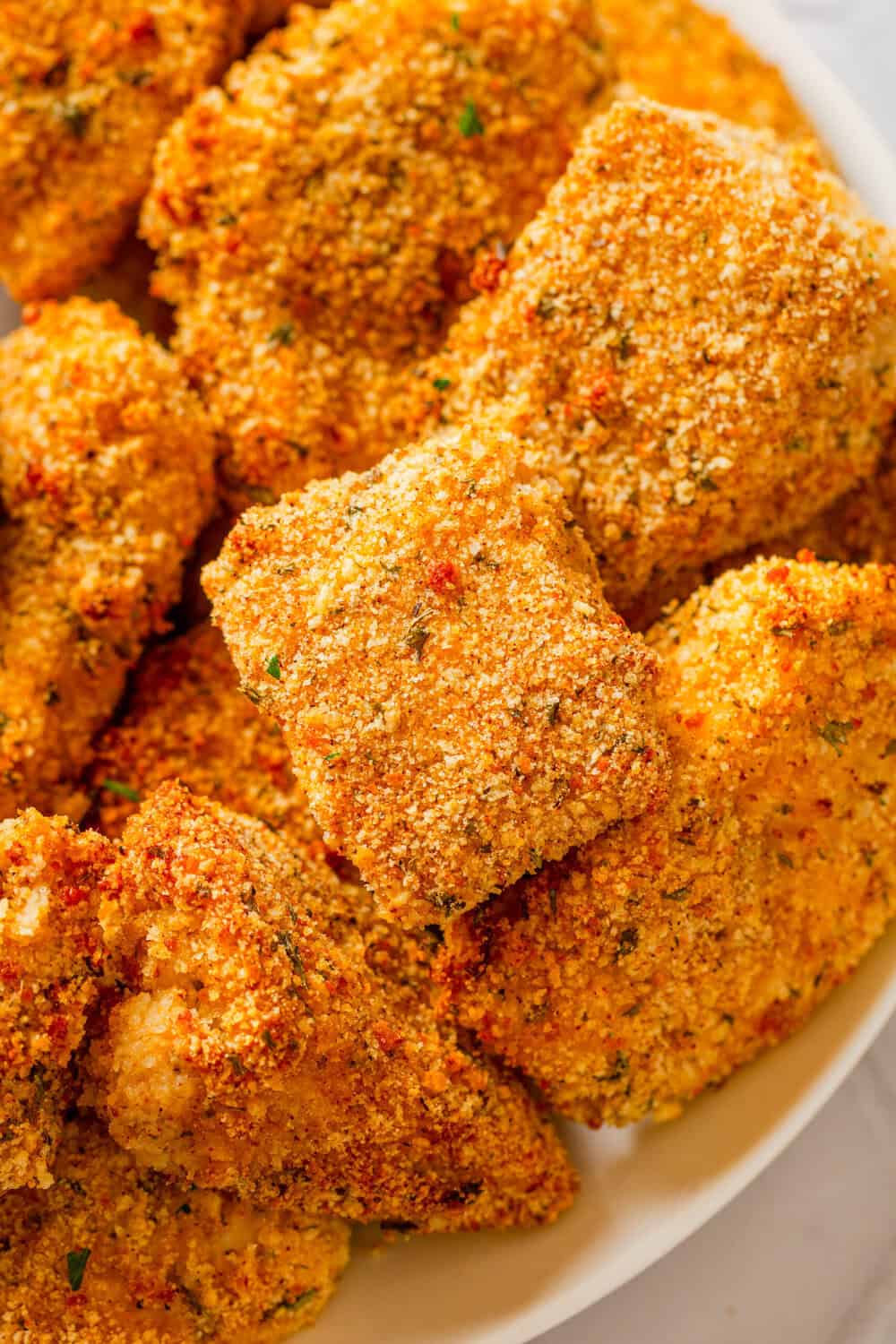 Air fryer cooked breaded chicken nuggets on a plate. 