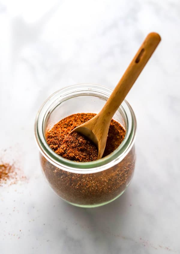 Spice jar filled with a spice blend with a spoon in it.
