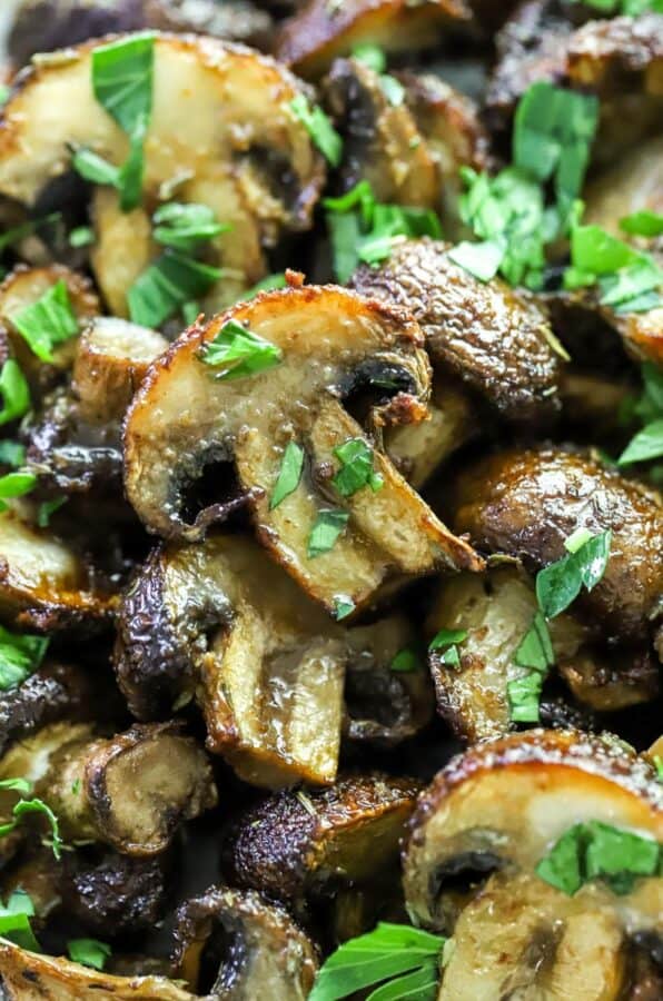 Close up shot of cooked mushrooms topped with chopped parsley