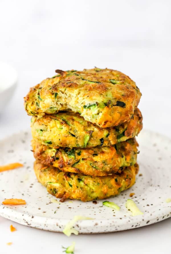 Vegetable patties stacked with a bite taken out of the top one.