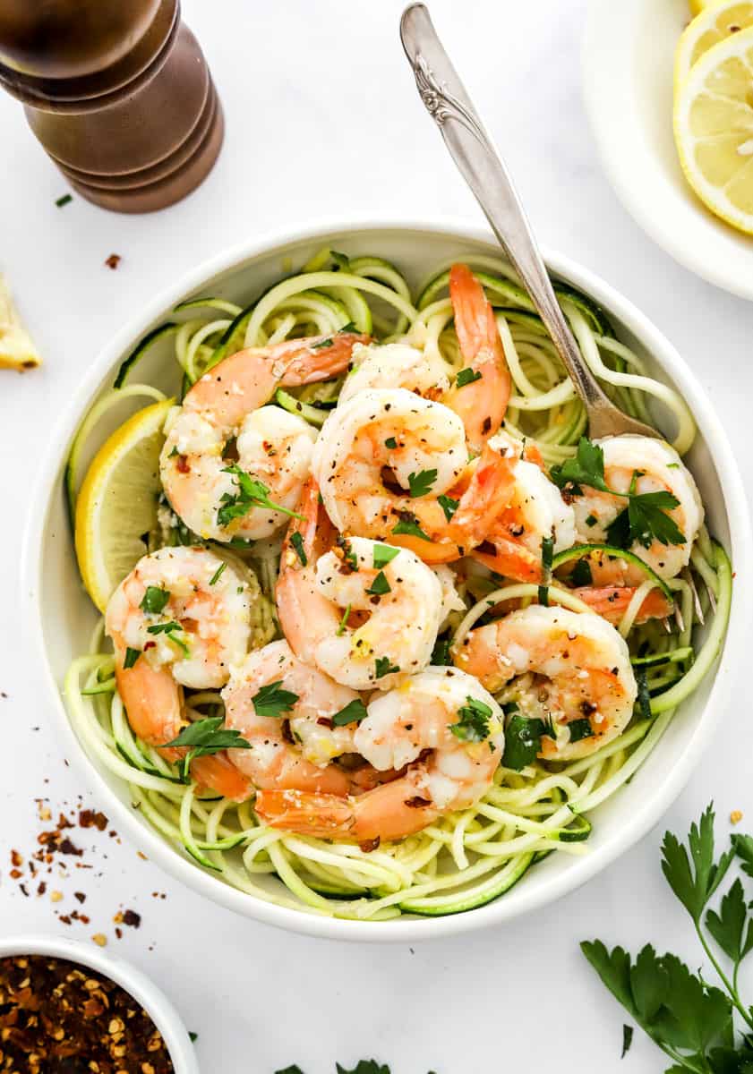 Shrimp pasta dish with zucchini noodles in a bowl with a fork in the bowl. 