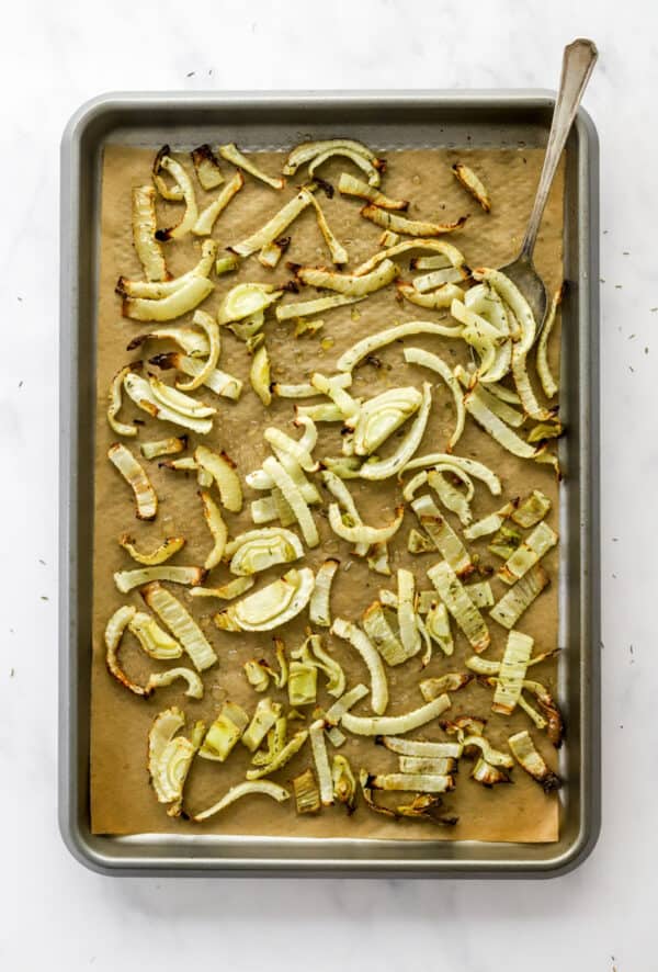 Roasted fennel on a lined baking sheet.