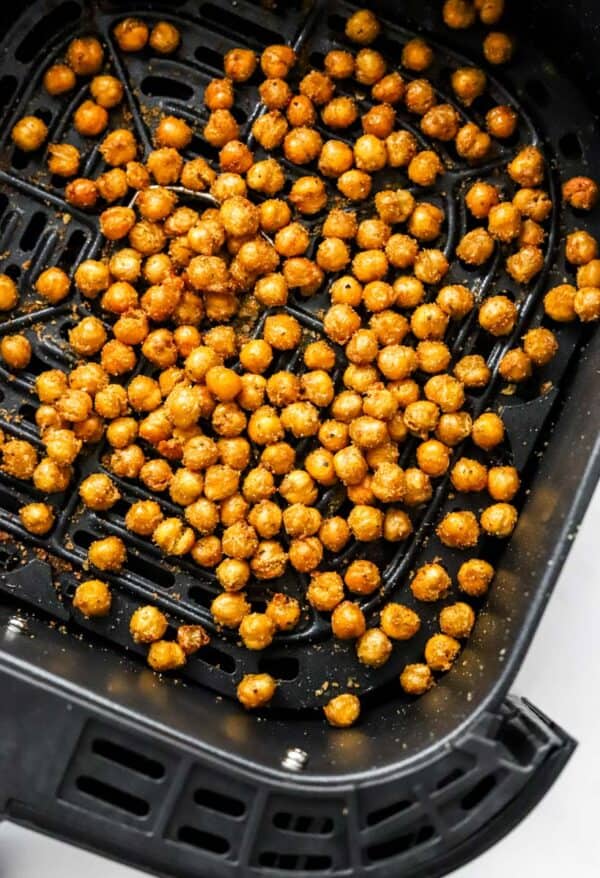 Roasted chickpeas in a black air fryer basket.