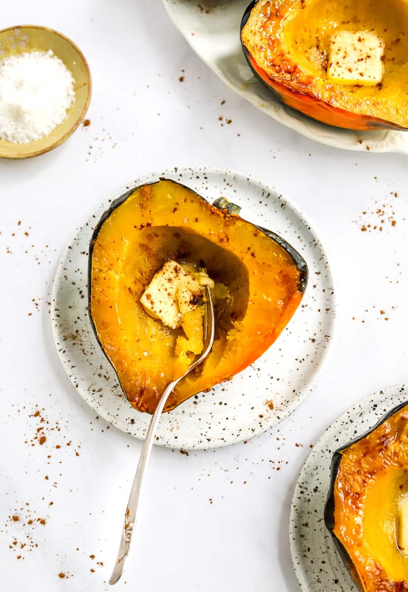 Place with golden squash on it with a fork in the squash with more squash in front of it and behind it.