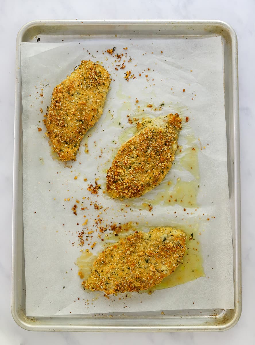 Crispy, cooked gluten free breaded chine on a baking sheet.