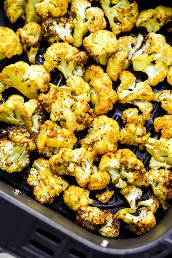 Close up of roasted cauliflower in a black basket.