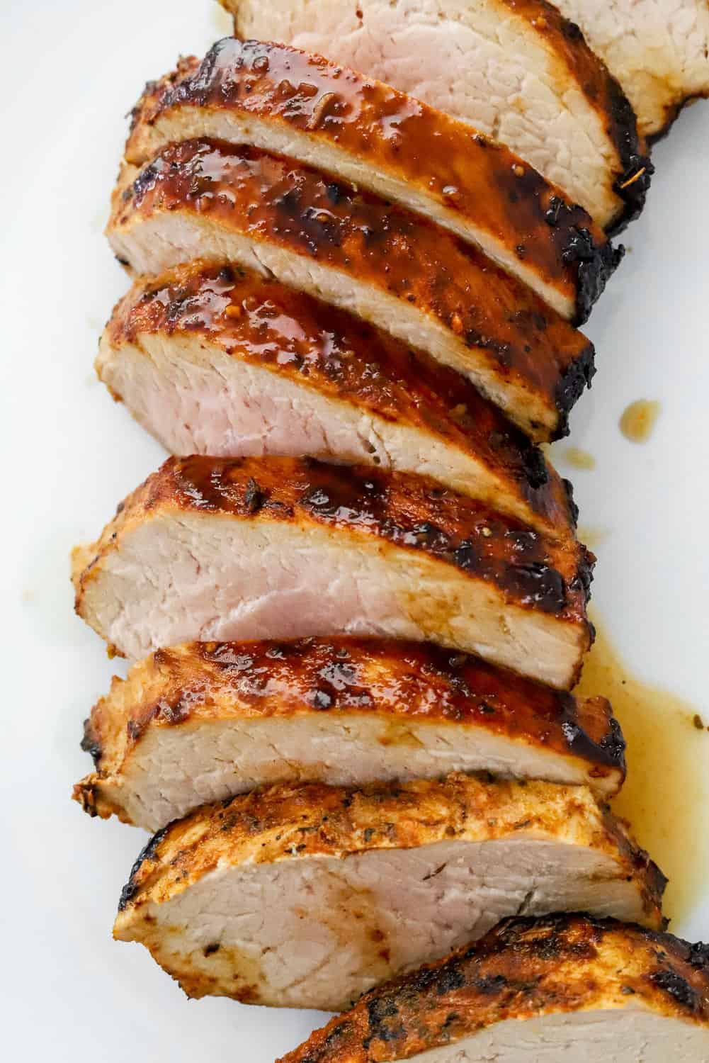 Cooked, sliced pork on a white plate.
