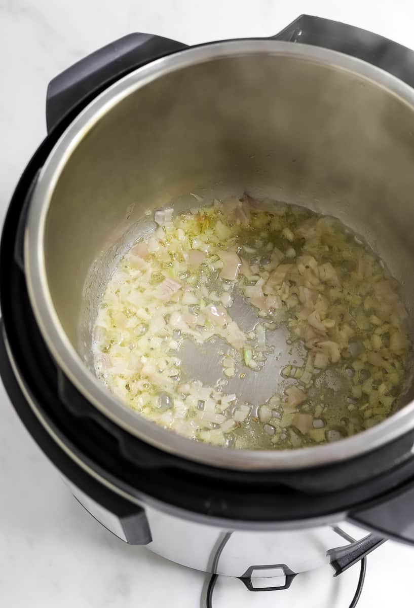 Onions and garlic in an instant pot cooking.