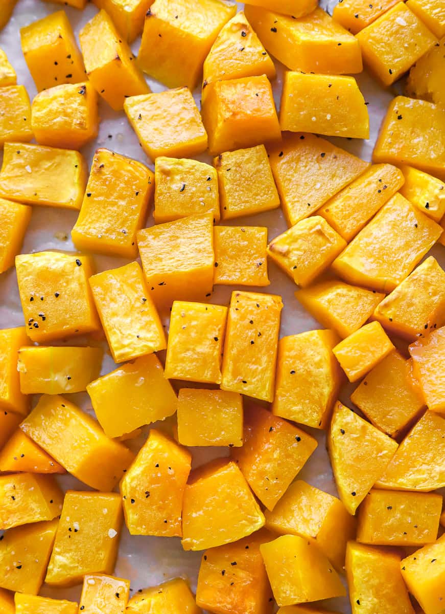 Close up of cubed roasted squash on a baking sheet. 