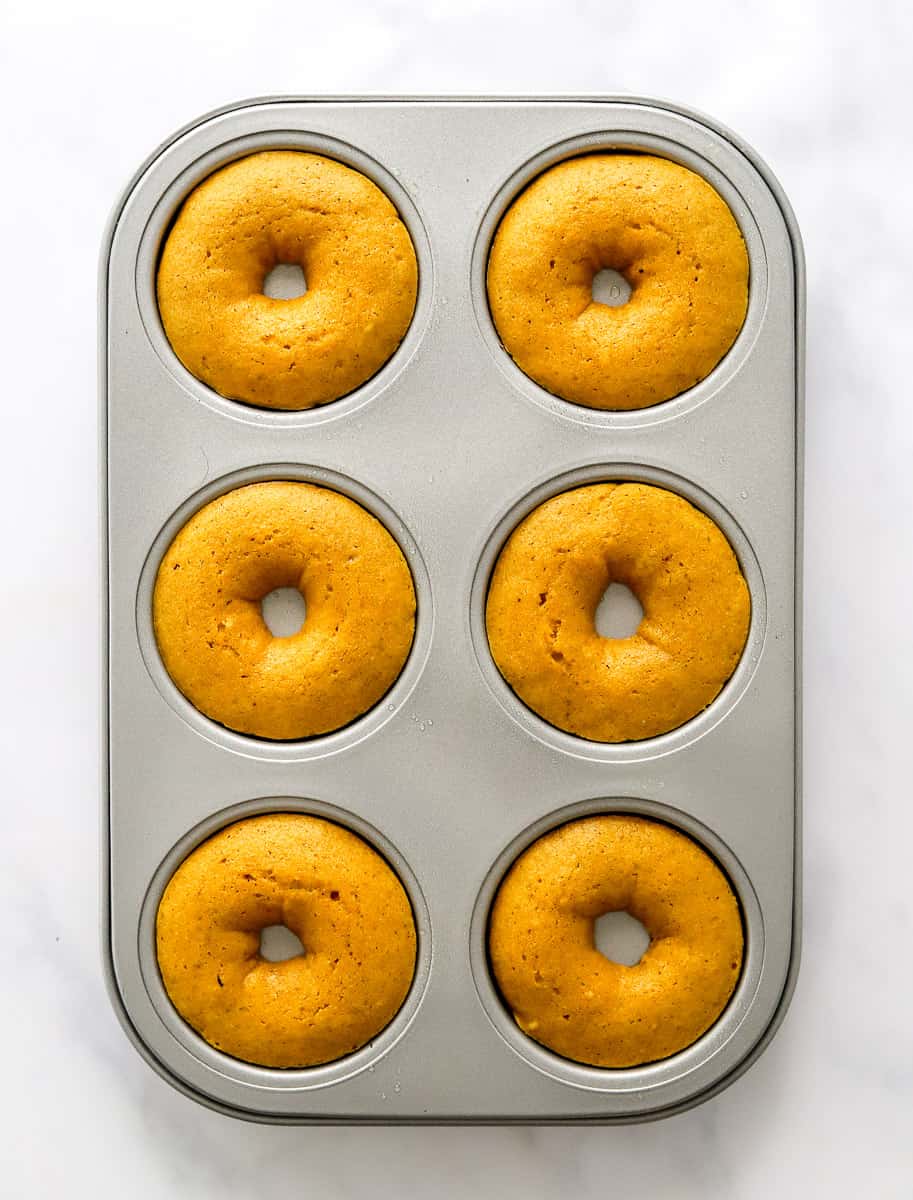 Baked pumpkin donuts in donut pan.