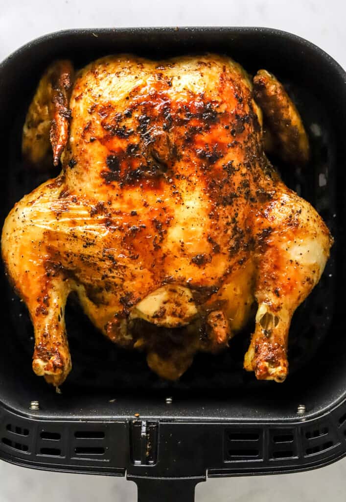 Golden cooked whole chicken in an air fryer.