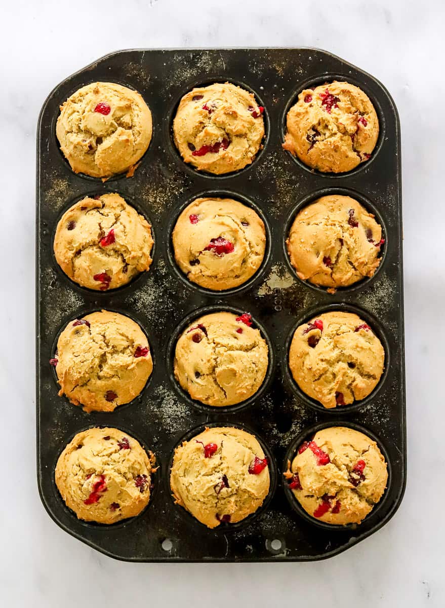 Baked cranberry orange muffins in a muffin pan.