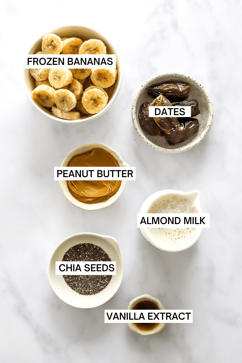 Ingredients for a date shake in bowls with labels over each ingredient.