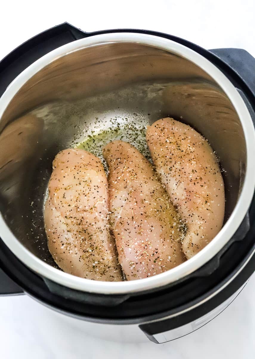 3 uncooked seasoned skinless chicken breasts in an instant pot.