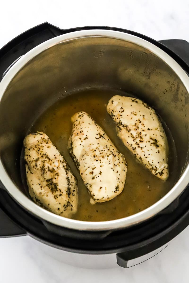 3 cooked, seasoned chicken breasts in an instant pot.